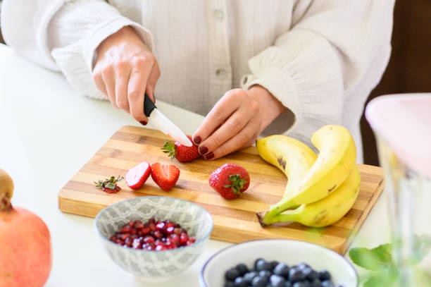 istock Unrecognizable woman cutting ripe strawberries on board 1493452005