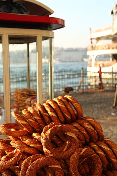 the traditional snack food of turkey..simit is sold by simitci from hand carts..ships and goldenhorn in background..