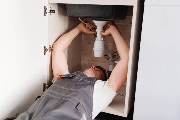 istock The plumber disassembles the siphon under the sink to clear the blockage. 1493456057