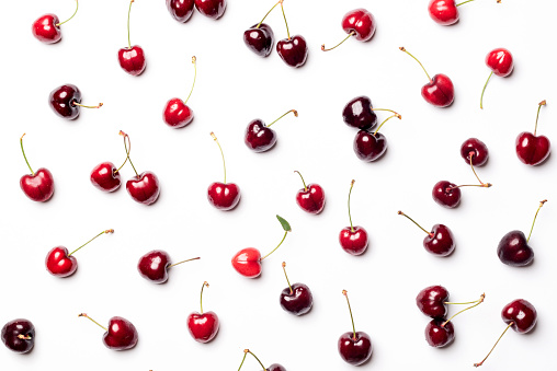 Set of red cherries isolated and separated from each other, on a white background. Nice background of red fruits rich in vitamins