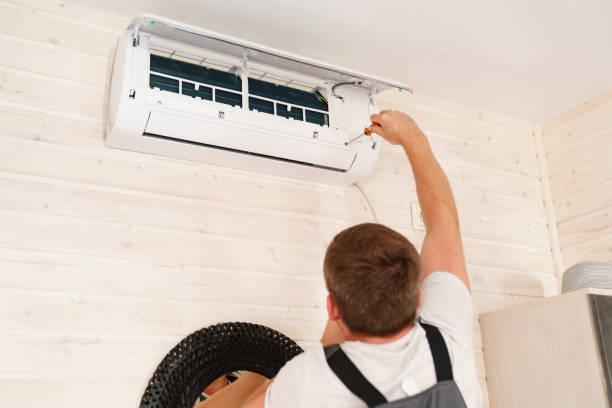 istock A man unscrews an air conditioner on the wall with a screwdriver 1493459332