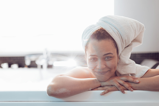 beautiful smiling young woman relaxing in bathtub