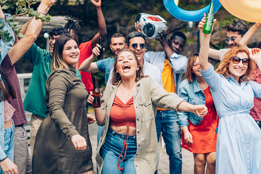 crowd of different people dancing and having a great time at a summer club party