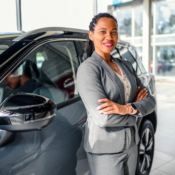 Portrait of a handsome female car saleswoman working in the showroom stock photo