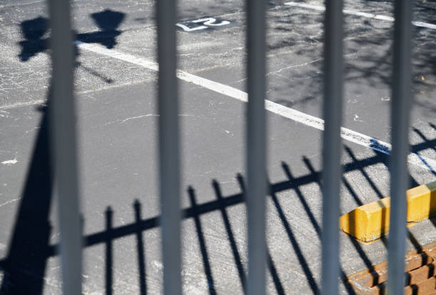 Enclosure and shadows on a ground of the parking in the city stock photo