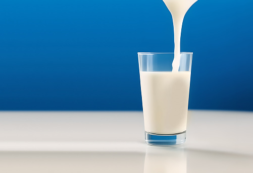 Fresh milk in the glass on blue background