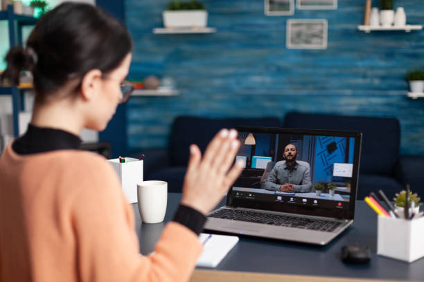 istock Student waving at teacher in online videocall lesson on laptop. 1493472546