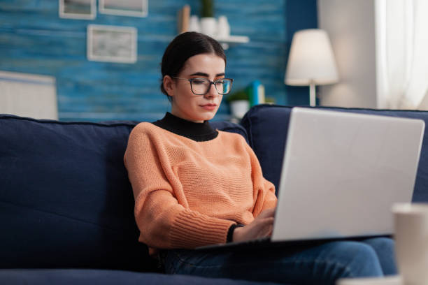 istock Student influencer on couch holding laptop and typing. 1493474120