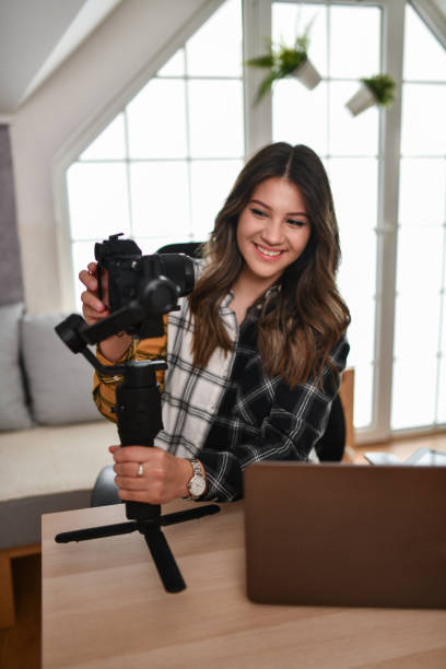 istock Cute Female Photographer Setting Up Camera At Home 1493476734