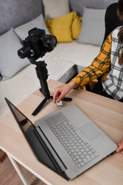 istock Female Using Memory Card To Transfer Images From Camera To Laptop 1493476866