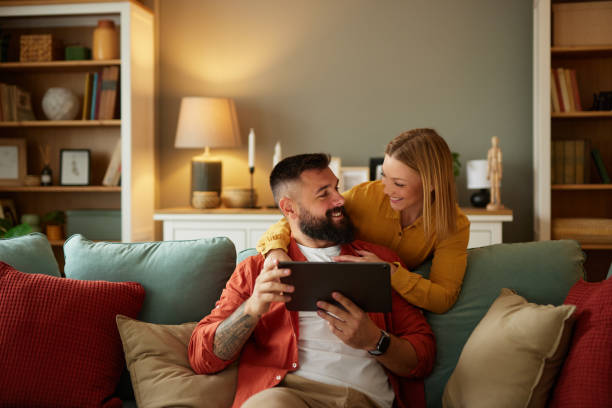 istock Handsome couple relaxing at home and looking at tablet 1493479659