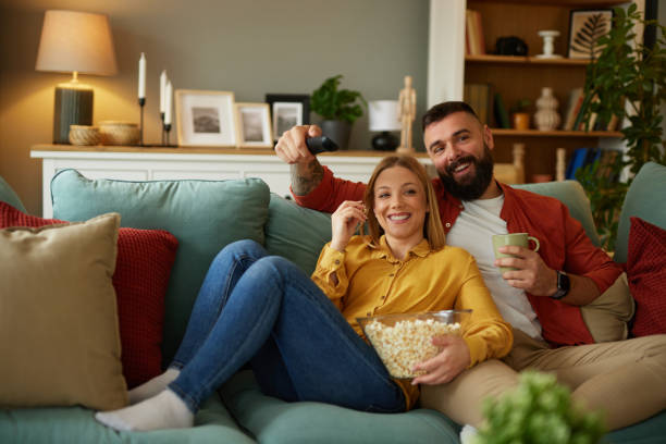 istock Couple watching movie on sofa at home 1493479698