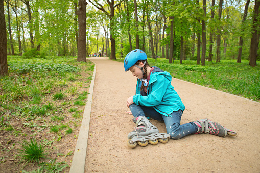 Child with roller skate in a park in summer or springtime