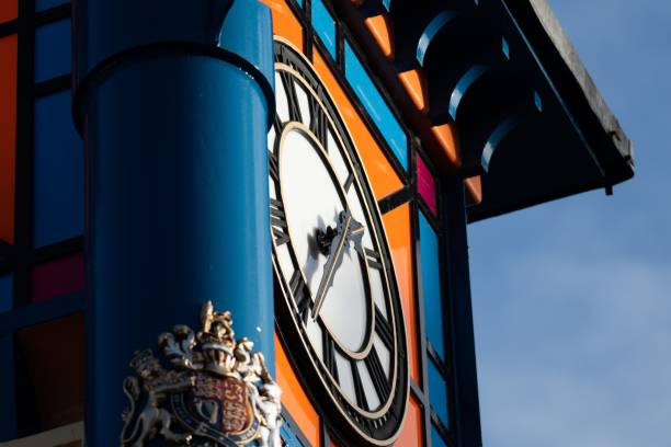 a blue pole with an orange clock face on it's side An upright blue post with an orange clock face mounted on its side Faceplate stock pictures, royalty-free photos & images