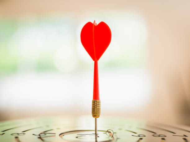 istock Darts with dartboard, sunset sky background hitting target. Achieve Goals - Success. 1493485610