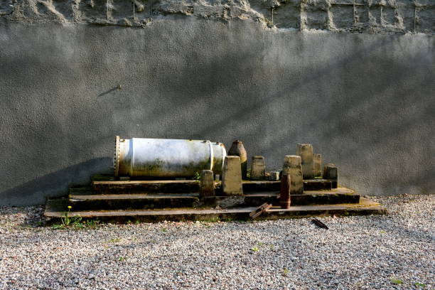 A close up on the collection of WWII shells, ammo, and bullets stored next to a concrete wall on metal, sturdy and rusty steps, next to some gravel spotted on a sunny spring day in Poland un primer plano de la colección de proyectiles, municiones y balas de la segunda guerra mundial almacenados junto a un muro de hormigón en escalones de metal, resistentes y oxidados, junto a un poco de grava visto en un soleado día de primavera en polon