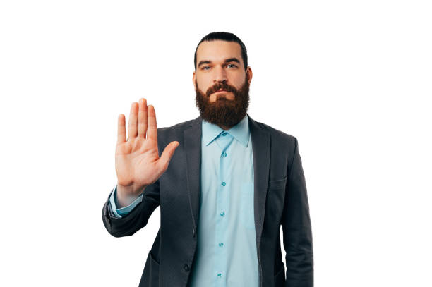 istock Serious bearded man wearing jacket says no and stop with his palm gesture. 1493489112