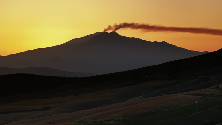 Mount Etna emitting smoke and ash at sunrise