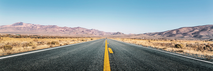 Panoramic view of an empty straight highway in desert
