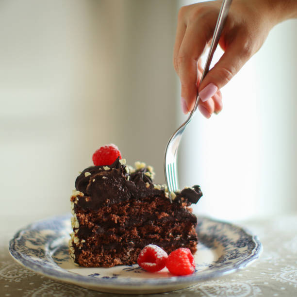 istock female hands try a cake with raspberry homemade cake in the kitchen 1493492640