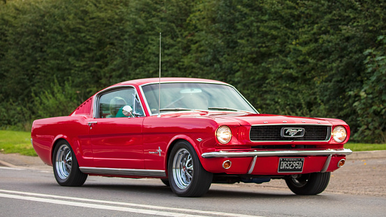 Bicester, Oxon, UK, October 10th 2021. 1966 RED FORD MUSTANG    classic car travelling on an English country road