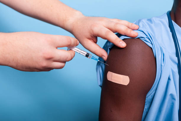 istock Close up of hands with syringe and needle vaccinating arm 1493495909