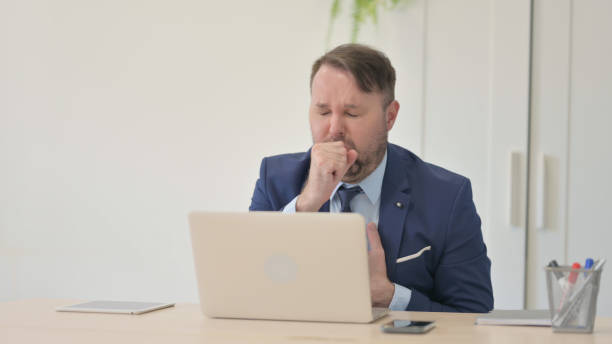 istock Businessman having Coughing Working on Laptop 1493501491