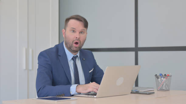 istock Shocked Businessman Working on Laptop 1493505611