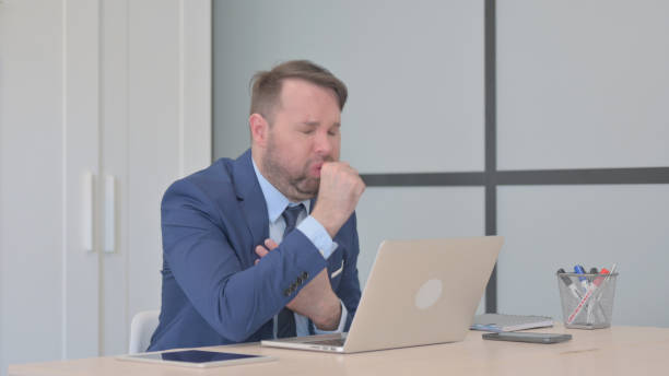 istock Businessman having Coughing Working on Laptop 1493505946