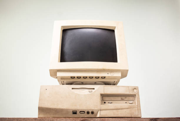 istock Front side of old and obsolete computer on old wood table with coloured concrete wall background 1493506133