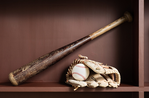 old baseball equipment at brown colored wooden ledge