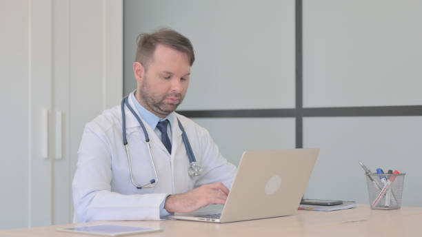 istock Busy Young Doctor Working on Laptop 1493507387