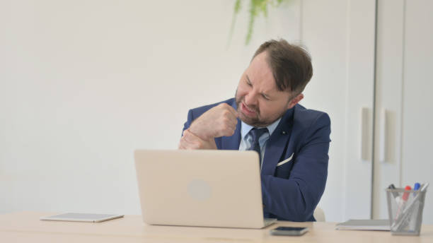 istock Businessman with Back Pain Working on Laptop 1493510185
