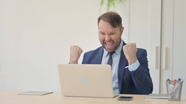istock Excited Businessman Celebrating Success on Laptop 1493511986