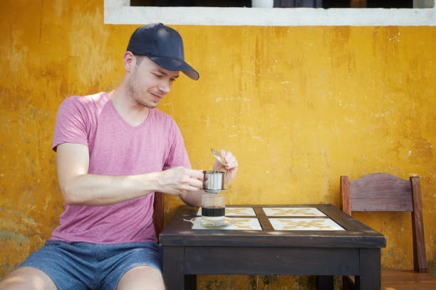 uomo che gode del bicchiere di caffè vietnamita caldo tradizionale - brown candid caffein drink foto e immagini stock