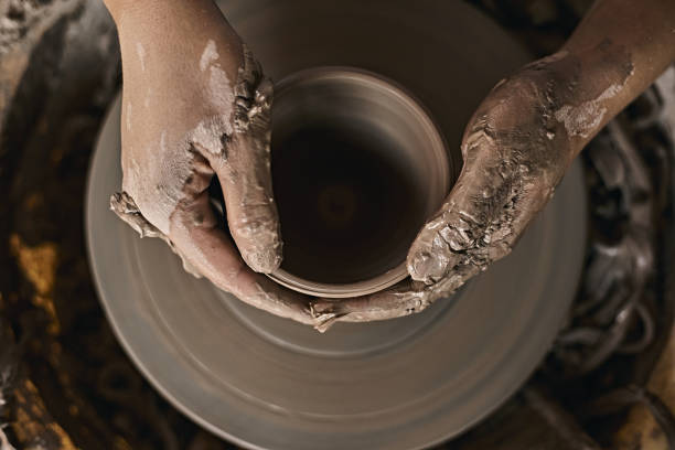 istock Hands of craftsman artist working on pottery wheel. 1493516074