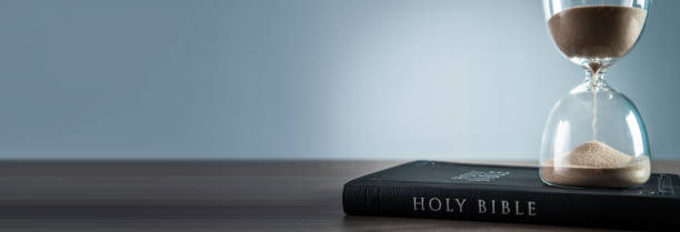 Hourglass and bible stock photo