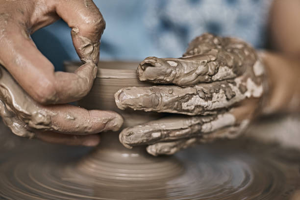 istock Hands of craftsman artist working on pottery wheel. 1493516247