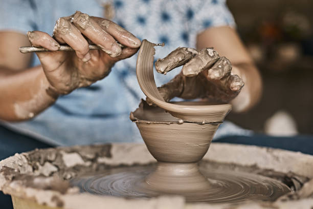 istock Hands of craftsman artist working on pottery wheel. 1493516352