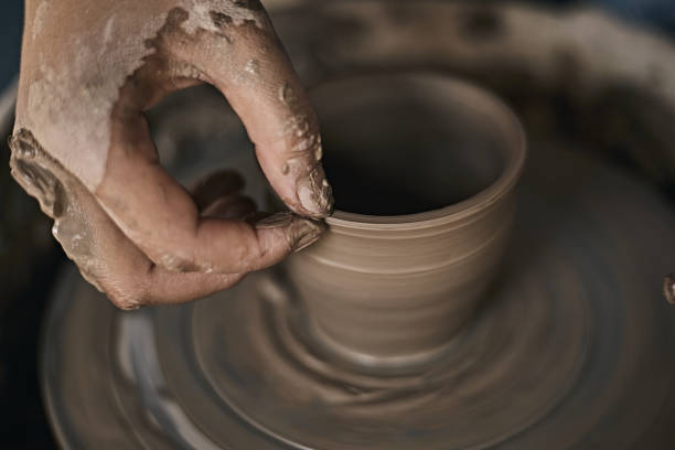 istock Hands of craftsman artist working on pottery wheel. 1493516509