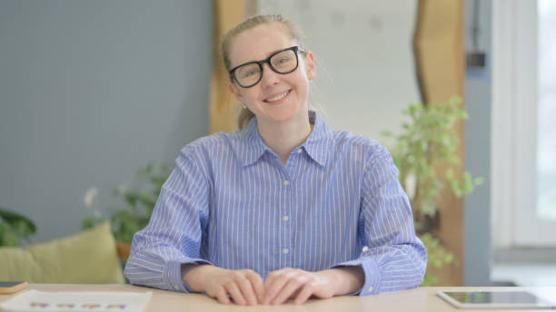 istock Smiling Young Woman Sitting at Work 1493516551