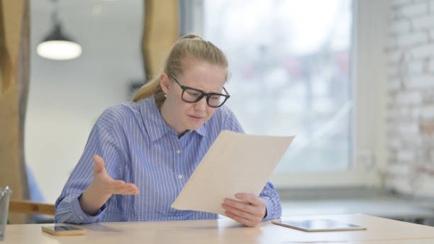 istock Young Woman Reacting to Business Loss while Reading Documents 1493519848