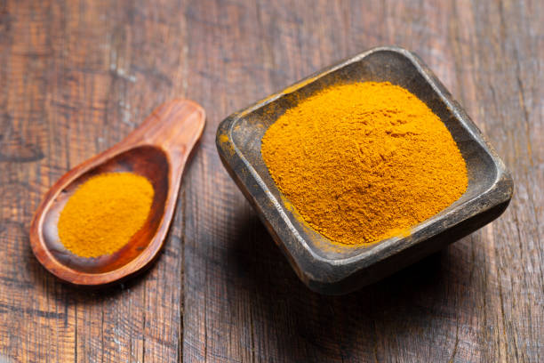 istock Turmeric, pepper and curry powder in container on wooden background 1493521756