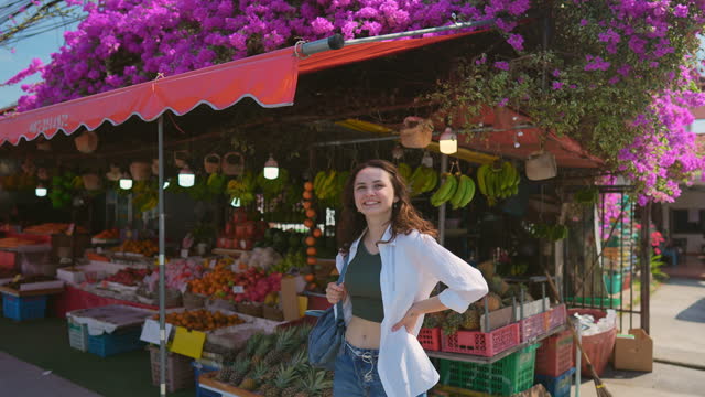Woman on the background of grocery store with tropical fruits