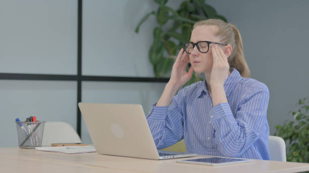 istock Young Woman with Headache Working on Laptop 1493524065