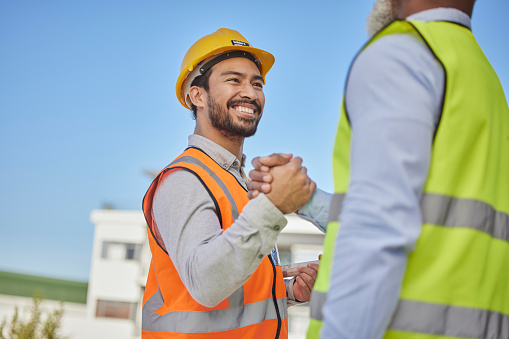 Engineer, men outdoor and greeting with handshake, partnership and success for new project. Architecture, coworkers or male employees with agreement, friends or collaboration for building development