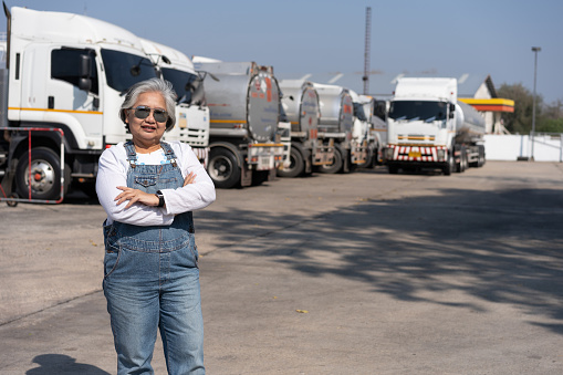 Business owner standing in front of oil truck after performing a pre-trip inspection on a truck. Concept of preventive maintenance.