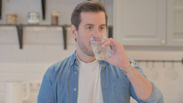 istock Portrait of Young Man Drinking Water at Home 1493529357