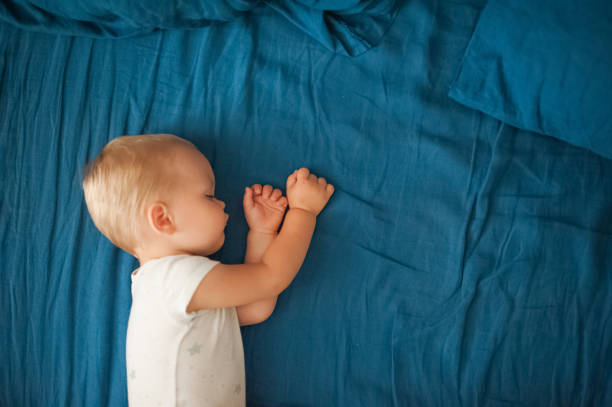 istock Toddler sleeps close-up on bed with blue plaid.. 1493533972