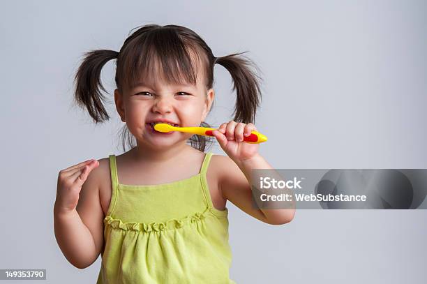 Young Girl Brushing Teeth With Yellow Toothbrush Stock Photo - Download Image Now - Child, Brushing Teeth, Toothbrush